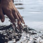 Touch - Close-Up Photo of a Person's Hand Touching Body of Water