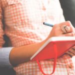 Journaling - Person Writing on Red Notebook