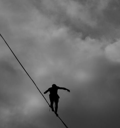 Balance - Low Angle Photo Grayscale of Person Tightrope Walking