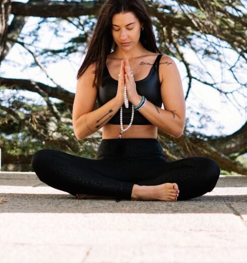 Mindfulness - Woman in Black Tank Top and Black Pants Sitting on Concrete Floor