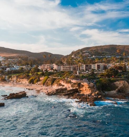 Adventures - Brown Mountains with Buildings Beside Blue Sea