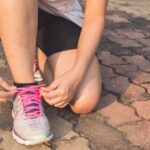 Wellness - Woman Lacing Up Her Gray and Pink Nike Low-top Athletic Shoe