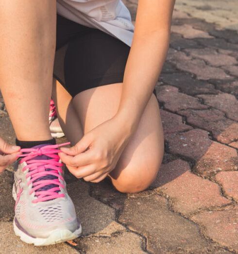 Wellness - Woman Lacing Up Her Gray and Pink Nike Low-top Athletic Shoe