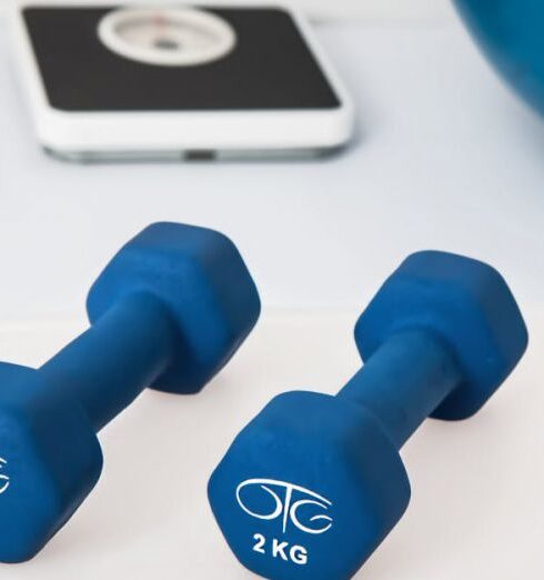 Wellness - Two 2 Kg. Blue Hex Dumbbells on White Surface