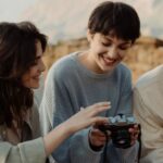 Adventures - A Group of People Looking at Photo Shots in a Camera