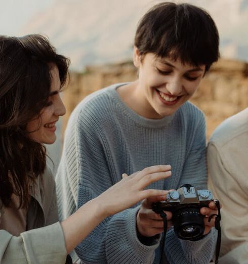 Adventures - A Group of People Looking at Photo Shots in a Camera