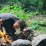 Survival - Man Checking Bonfire at Forest