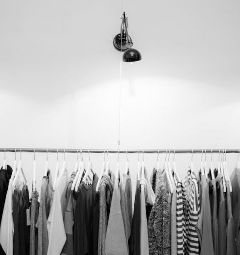 Clothing - Grayscale Photography of Assorted Shirts Hanged on Clothes Rack