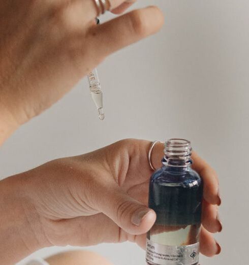 Routines - Close-up View of Hands Holding Glass Bottle and Pipette