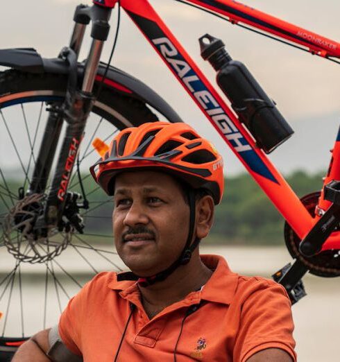 Routine - Photo of Man Wearing Orange Polo Shirt Sitting Beside His Bike