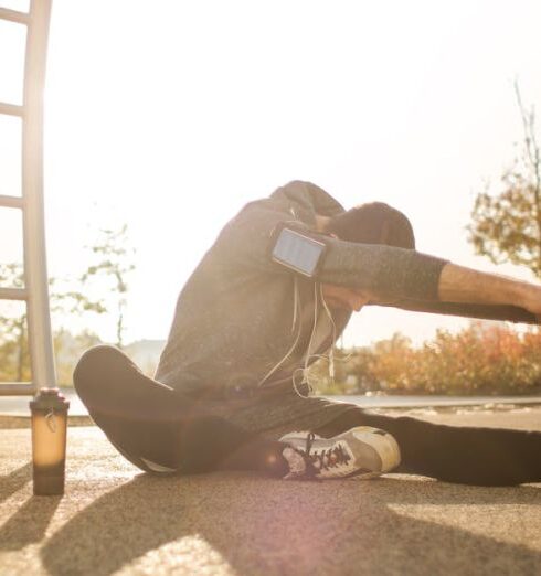 Warm Up - Flexible sportsman stretching on sports ground