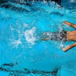 Swimming - Person Swimming on Body of Water