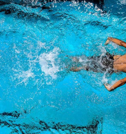 Swimming - Person Swimming on Body of Water