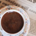 Routines - Cup of Black Coffee Lying on Newspaper in Bed