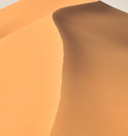 Travel - A Person Walking in the Middle of the Hot Desert