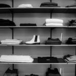 Clothing - Grayscale Photography of Assorted Apparels on Shelf Rack