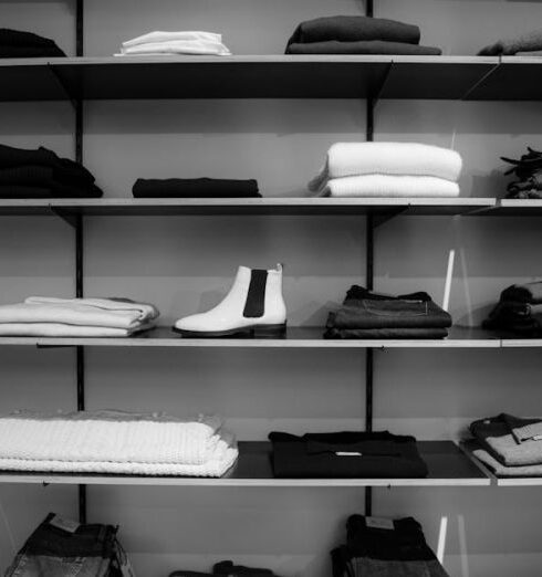 Clothing - Grayscale Photography of Assorted Apparels on Shelf Rack