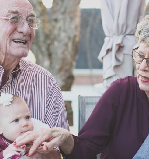 Seniors - Grandmother and Grandfather Holding Child on Their Lap