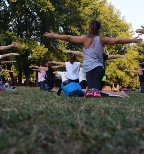 Wellness - Women Performing Yoga on Green Grass Near Trees