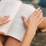 Self-Care - Woman Reading Book Sitting on Rock above Sea