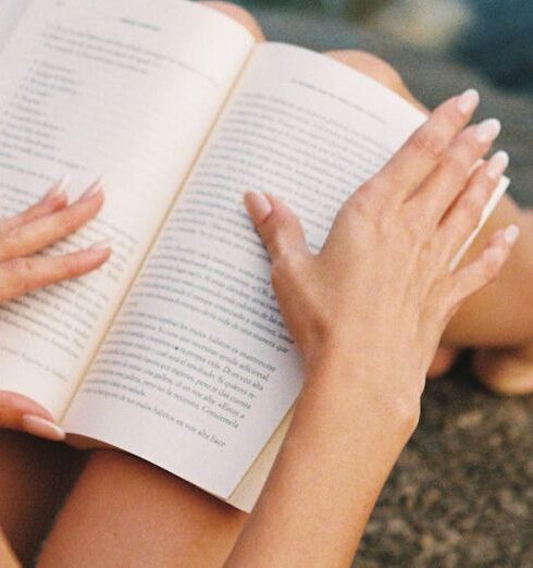 Self-Care - Woman Reading Book Sitting on Rock above Sea