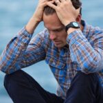 Stress - Man in Blue and Brown Plaid Dress Shirt Touching His Hair