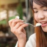 Eating - Woman Holding Spoon Trying to Eat White Food