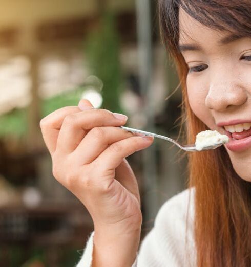 Eating - Woman Holding Spoon Trying to Eat White Food