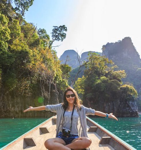 Travel - Photo of Woman Sitting on Boat Spreading Her Arms