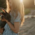 Pet - Woman in Blue Dress Holding Black and Brown Short Coated Dog