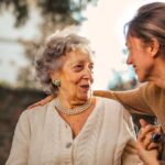 Care - Joyful adult daughter greeting happy surprised senior mother in garden