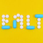 Health - White and Blue Health Pill and Tablet Letter Cutout on Yellow Surface