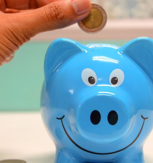 Savings - Person Putting Coin in a Piggy Bank