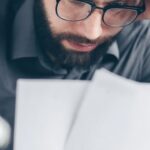 Costs - Man in Black Long Sleeve Shirt Holding White Papers