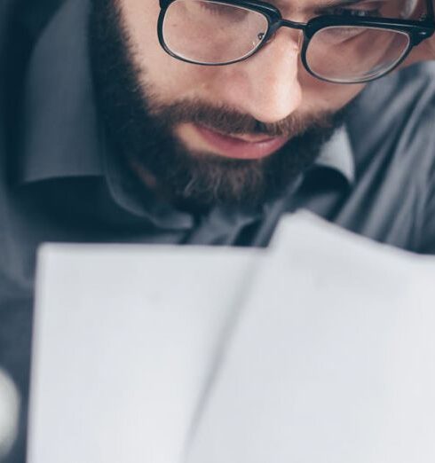 Costs - Man in Black Long Sleeve Shirt Holding White Papers