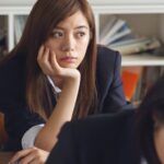 Distractions - Woman Holding Chin Sitting Beside Table in Room