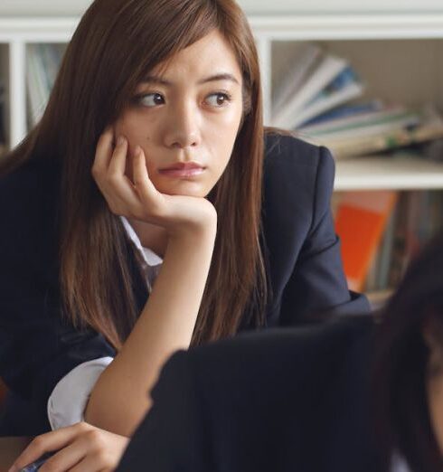 Distractions - Woman Holding Chin Sitting Beside Table in Room