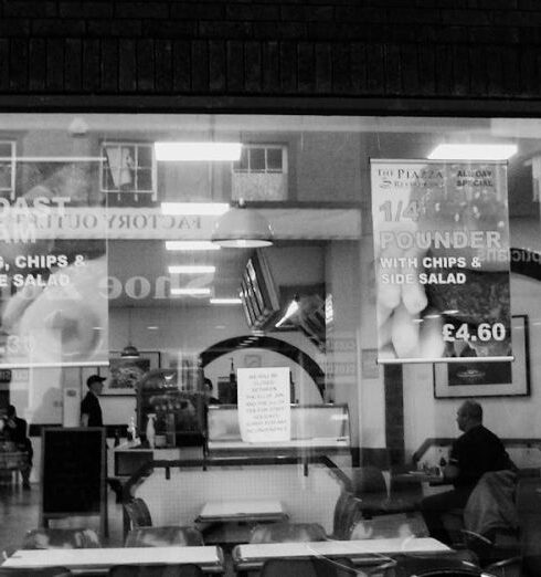 Meals - Chairs and Tables in Front of a Restaurant in Black and White