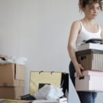 Clutter - Concentrated woman carrying stack of cardboard boxes for relocation