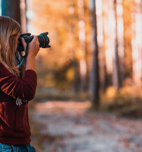 Lifestyle - Woman Leaning Back on Tree Trunk Using Black Dslr Camera during Day