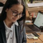 Tasks - Young Women Sitting at the Desk with Laptops in an Office