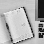 Planner - Flat Lay Photography of Unfold Book Beside Macbook