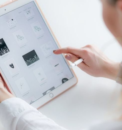 App - Woman Sitting Beside Table While Using Ipad