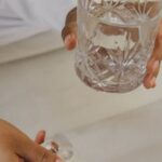 Tips - Person in Bed Holding Glass of Water and Medicines