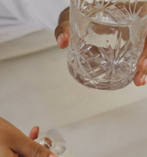 Tips - Person in Bed Holding Glass of Water and Medicines