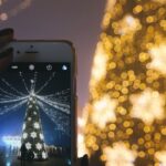 Holidays - Person Taking Picture of Gold Lighted Tree