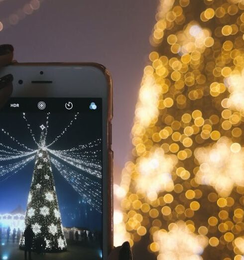 Holidays - Person Taking Picture of Gold Lighted Tree