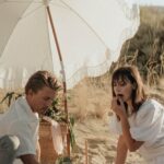 Commitments - Young couple having picnic on sandy terrain