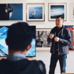 Mentoring - Man Beside Flat Screen Television With Photos Background