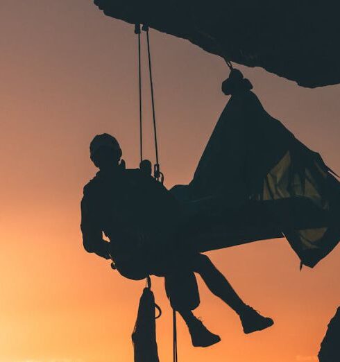 Solo Adventure - Silhouette Photo of Person Hanging by the Cliff